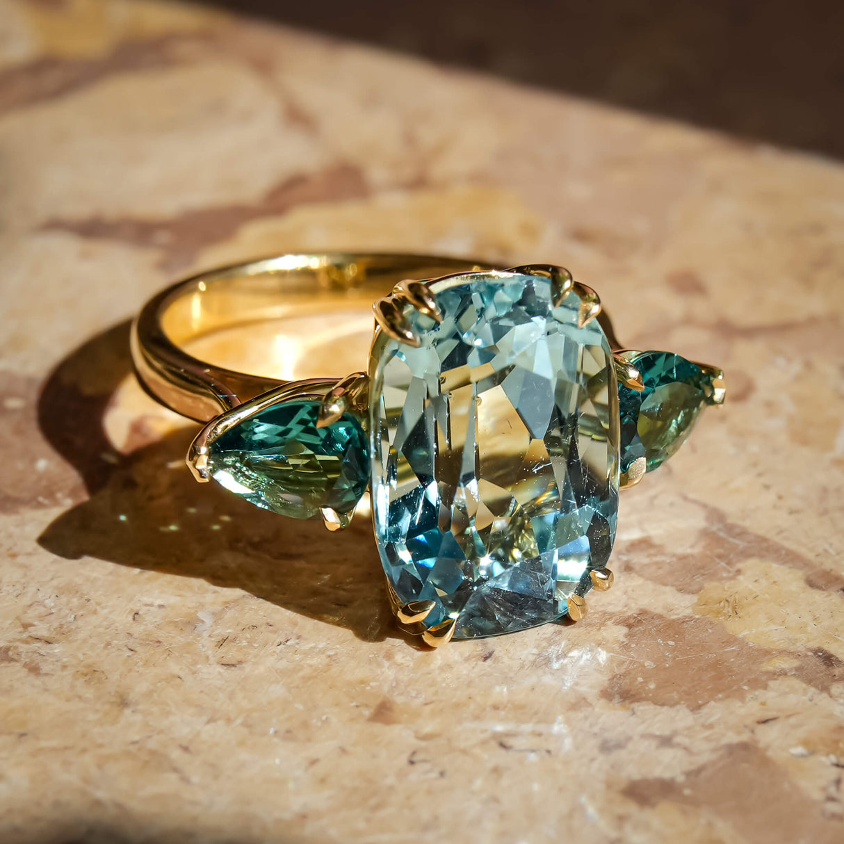 Aquamarine and sea green tourmaline three stone cocktail ring in yellow gold
