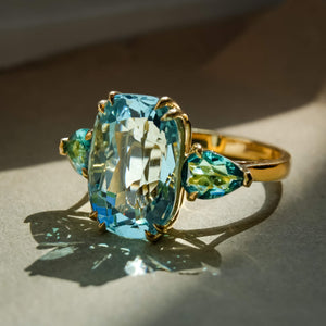 Aquamarine and tourmaline cocktail ring in yellow gold with three stones