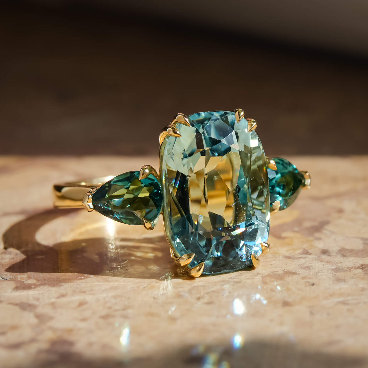 Aquamarine and tourmaline three stone cocktail ring with oval center stone