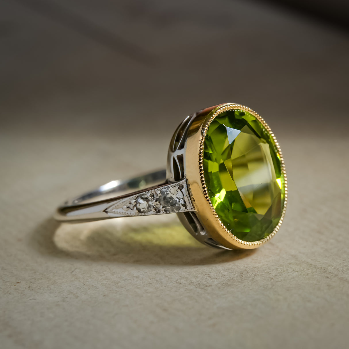 Art Deco peridot ring set in gold with oval green gemstone and diamonds