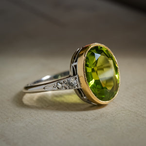 Art Deco peridot ring set in gold with oval green gemstone and diamonds