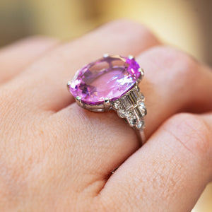 Art Deco pink topaz and diamond cocktail ring showing faceted pink topaz and diamond set shoulders on hand.