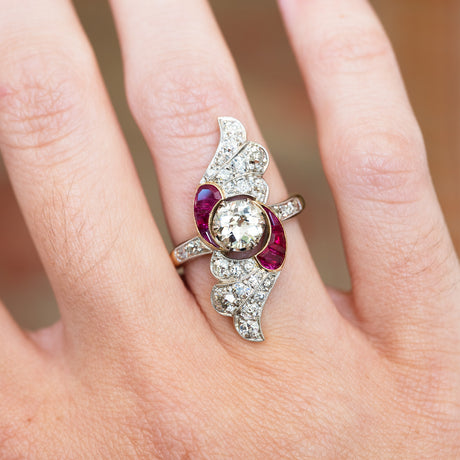 Diamond and ruby cocktail ring close detail showing curved design and central stone.