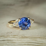 Blue sapphire three-stone ring with round centre and diamond trefoil accents