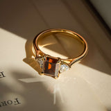 emerald cut brown diamond three stone ring with white diamond side stones