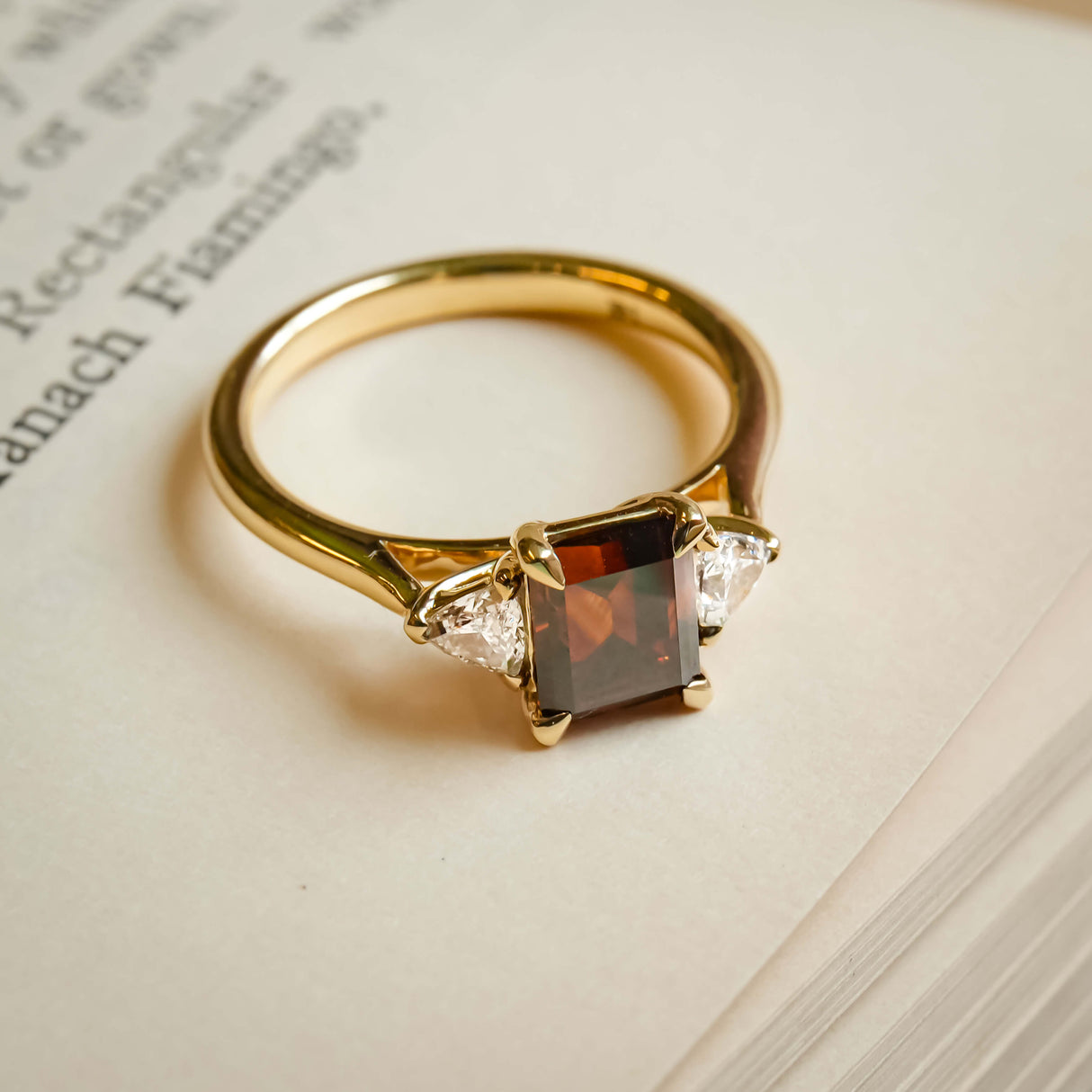 brown diamond three stone engagement ring with white diamond side stones in yellow gold