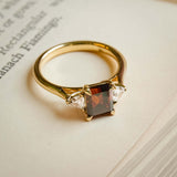 brown diamond three stone engagement ring with white diamond side stones in yellow gold