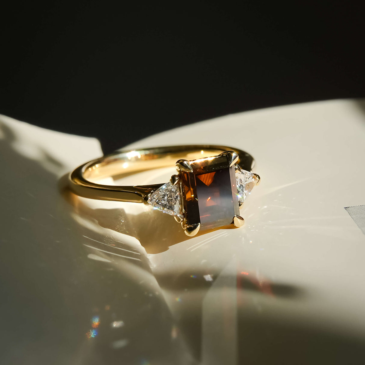 brown diamond three stone ring with yellow gold band and side diamonds