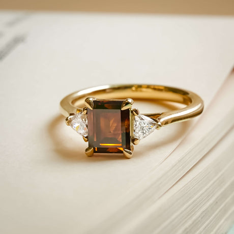 brown diamond three stone ring with white diamond accents in yellow gold