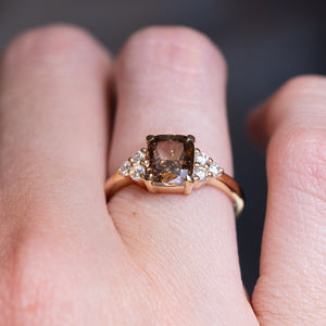 Chocolate brown diamond cluster tre-foil engagement ring worn on finger with diamond side stones.