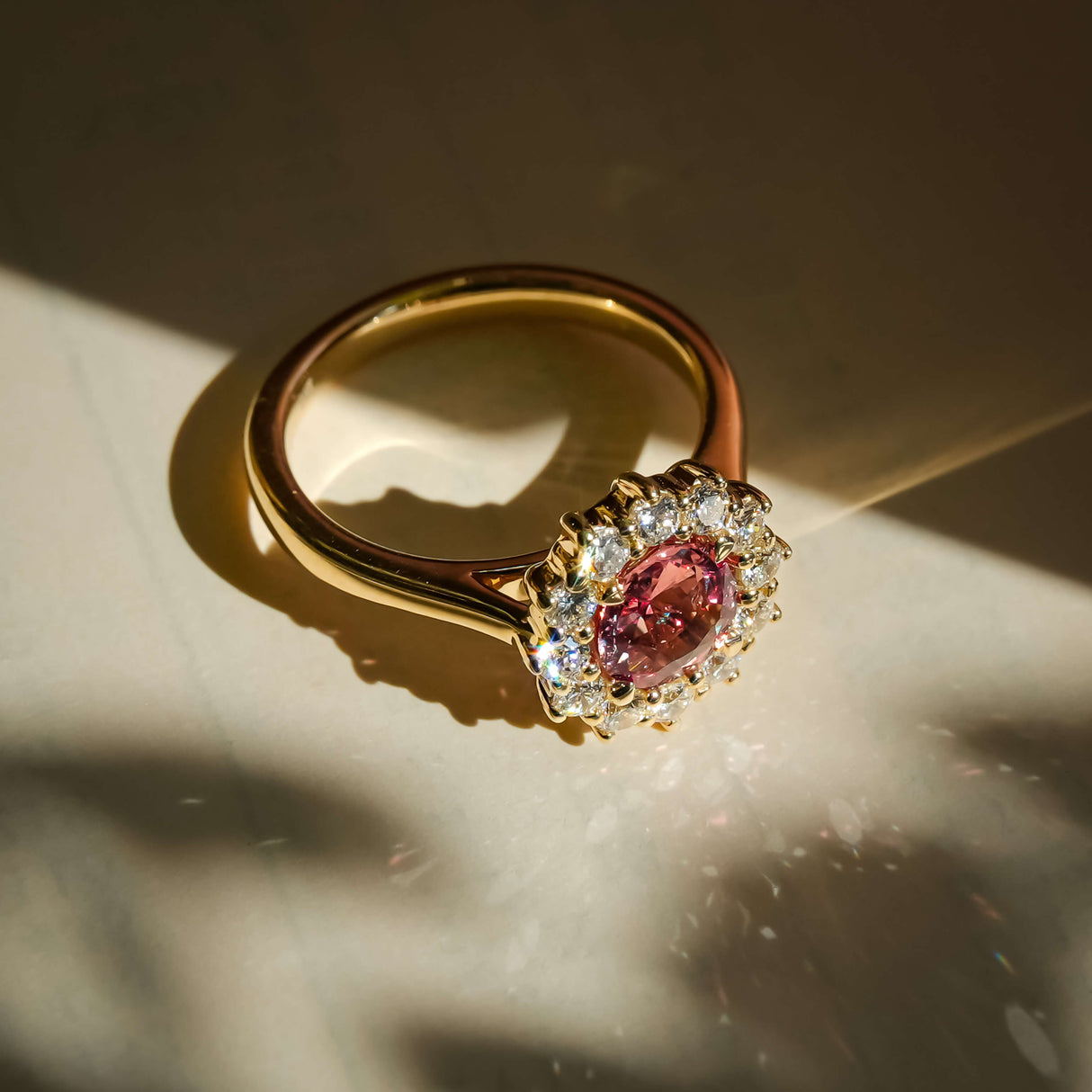 burnt orange sapphire and diamond cluster engagement ring in yellow gold with halo
