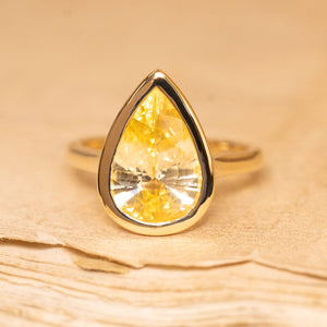Canary yellow pear-cut sapphire solitaire ring featuring a vibrant yellow sapphire set in polished yellow gold.