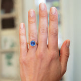 Cornflower blue sapphire solitaire ring worn on hand with natural manicure.