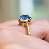Sapphire solitaire ring showing detailed gold setting and engraved band.