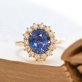 Cornflower blue sapphire and diamond cluster engagement ring in yellow gold.