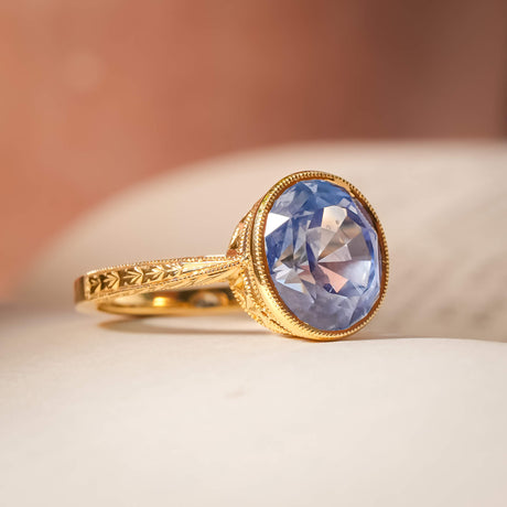 Cornflower blue sapphire solitaire ring with oval gemstone in yellow gold