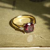 Cushion cut 3ct ruby with diamond three stone engagement ring in yellow gold
