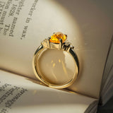 Cushion cut orange sapphire ring with diamond trefoil cluster setting