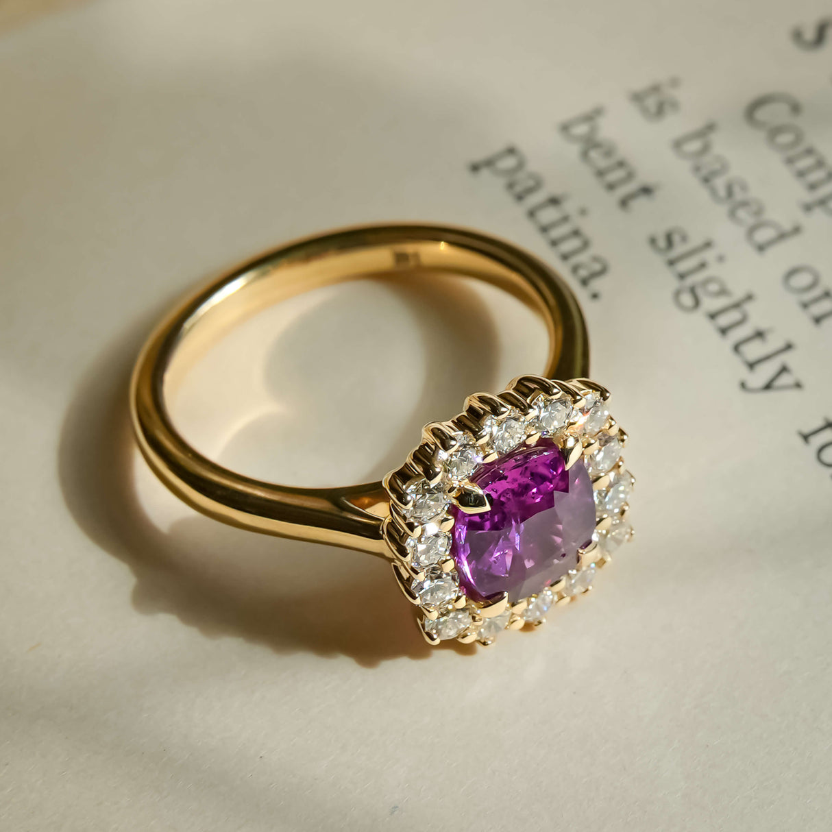 Cushion cut pink sapphire and diamond cluster engagement ring in yellow gold band