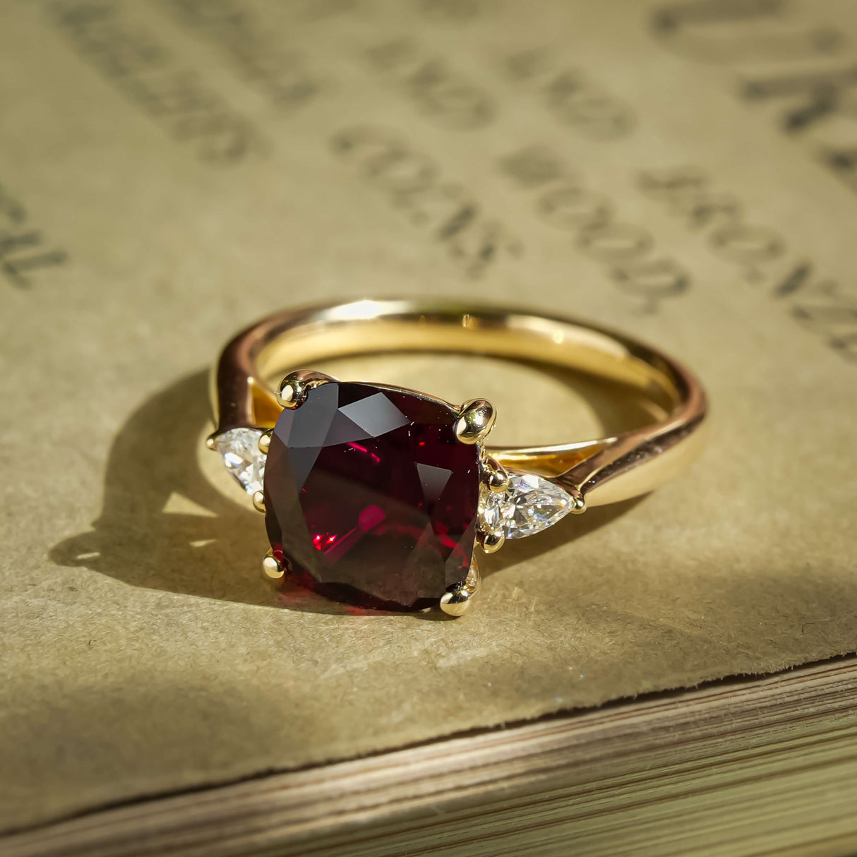 Cushion cut 3ct ruby and diamond three stone engagement ring in yellow gold