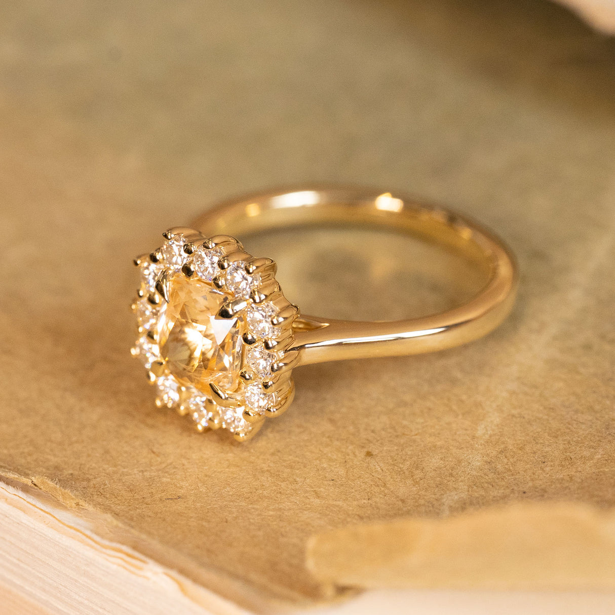 Yellow sapphire and diamond cluster ring with a vibrant cushion-cut sapphire and dazzling diamond halo set in yellow gold.