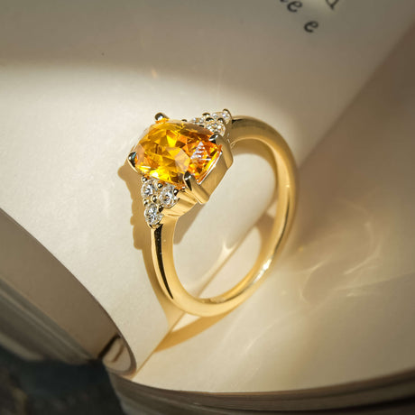 Cushion cut orange sapphire ring with diamond trefoil cluster design
