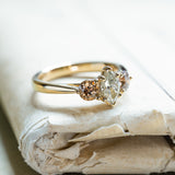 Diamond three-stone engagement ring with marquise centre diamond and warm-toned side diamonds on gold band.