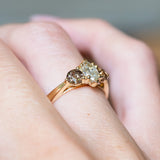 Diamond three-stone engagement ring with marquise-cut diamond and diamond accents on gold band.