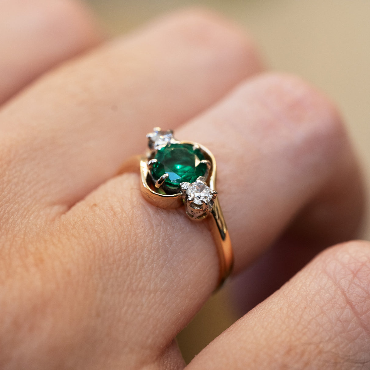 Emerald and diamond ring highlighting central green gemstone and delicate setting.