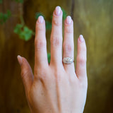 Antique Edwardian diamond cluster ring worn on hand with old cut diamonds.