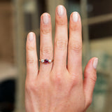 Ruby and diamond three stone ring worn on hand.