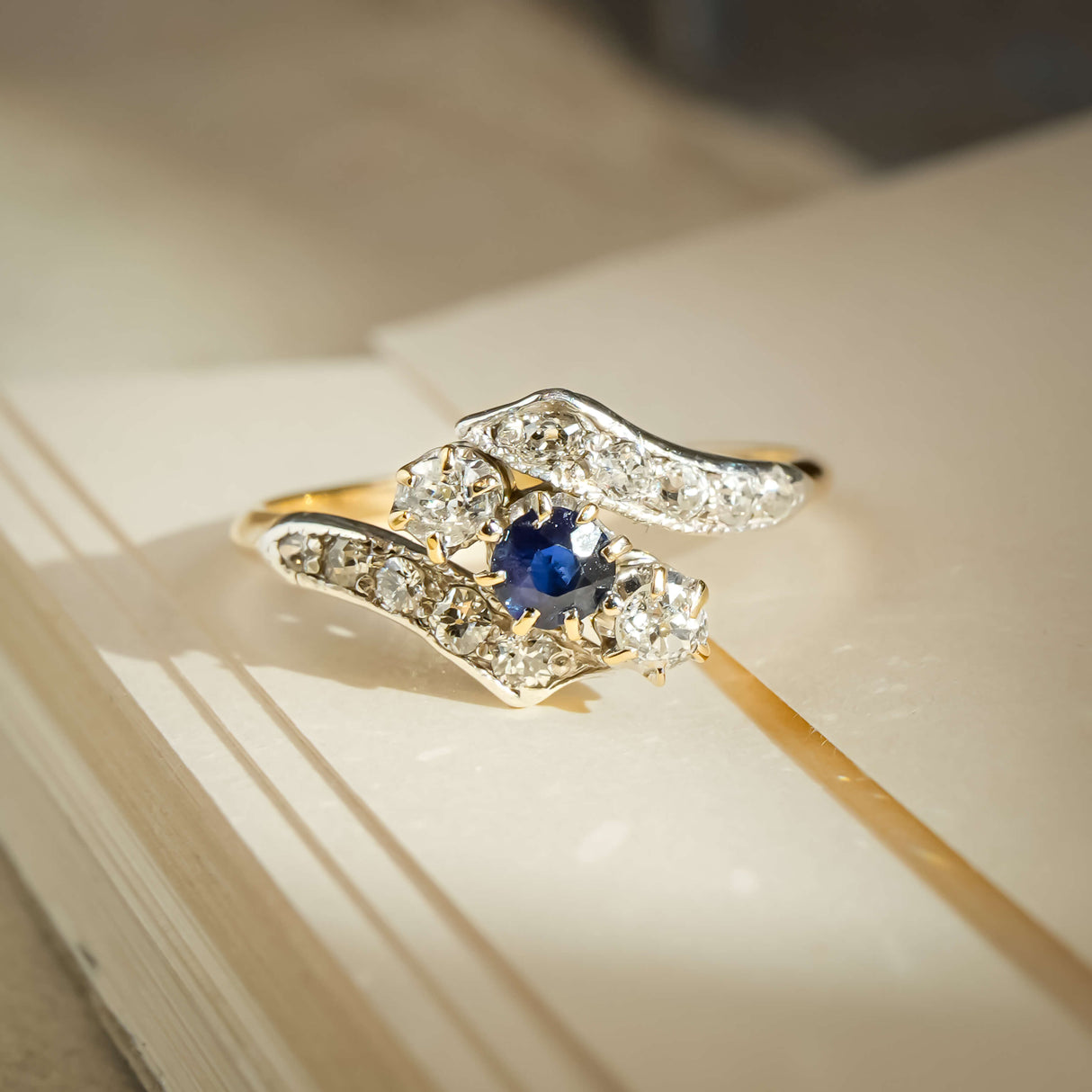 Edwardian sapphire and diamond twist ring with blue gemstone and diamond set curves