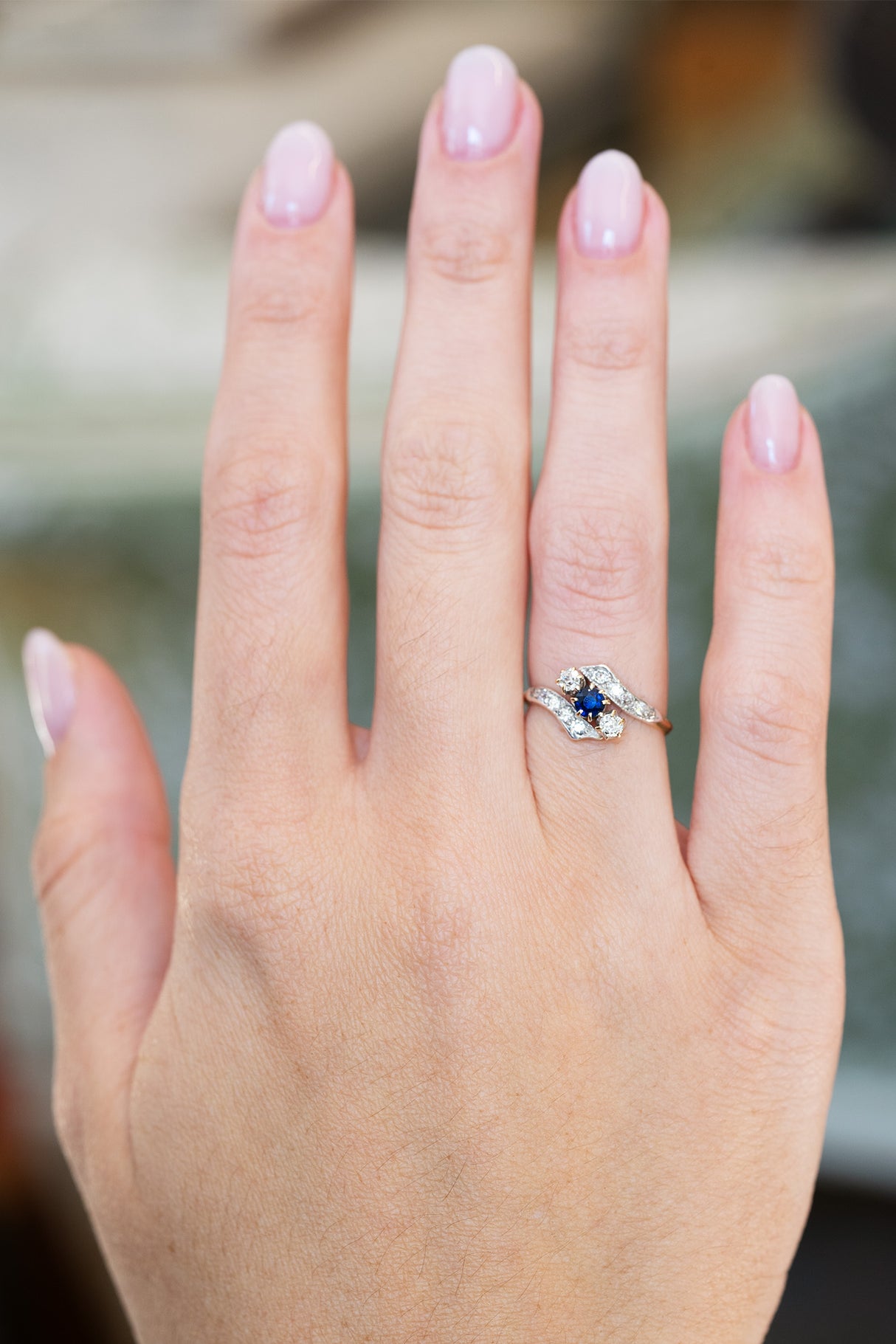 Edwardian sapphire twist ring with diamond accents worn on hand