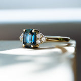 blue sapphire engagement ring with diamond cluster and yellow gold band