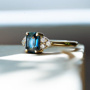 blue sapphire engagement ring with diamond cluster and yellow gold band