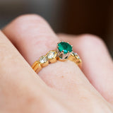 Emerald five stone ring detail highlighting setting and diamond spacing.