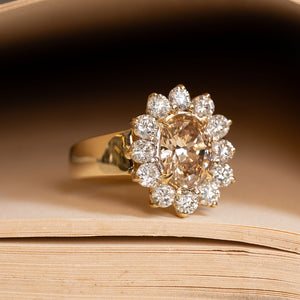 Vintage brown diamond cocktail ring with an oval fancy coloured brown diamond framed by a halo of brilliant-cut diamonds.