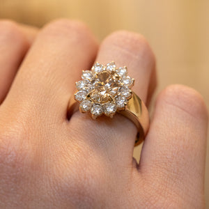 Detailed view of a vintage 1980s brown diamond cocktail ring worn on the hand, featuring an oval fancy coloured brown diamond and diamond cluster surround.