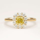 Fancy yellow cushion-cut yellow diamond cluster engagement ring in yellow gold.