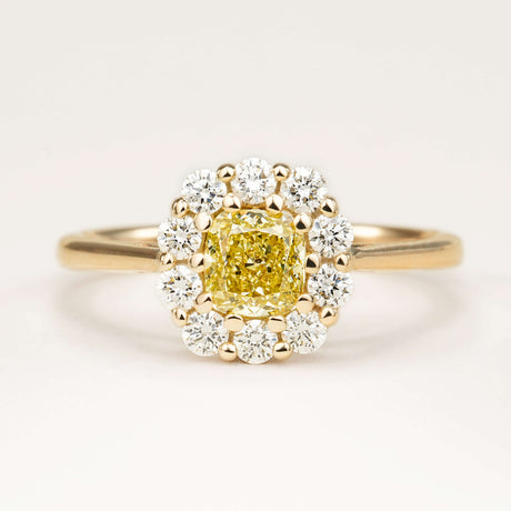 Fancy yellow cushion-cut yellow diamond cluster engagement ring in yellow gold.