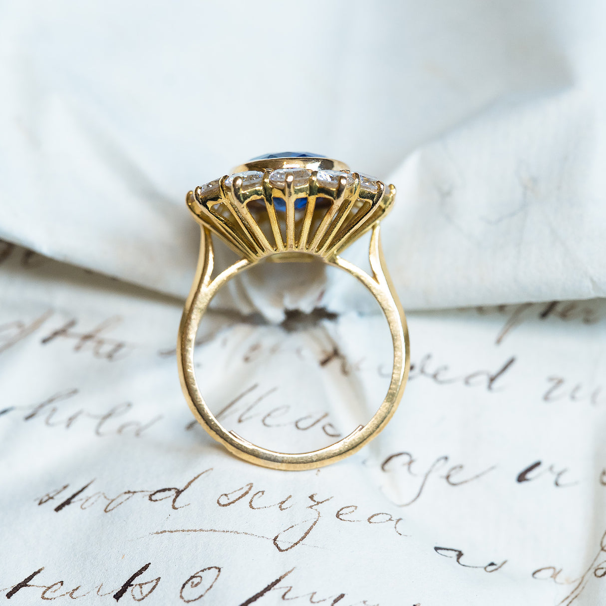 Vintage French sapphire and diamond cluster ring with fan-style gallery beneath oval sapphire setting.