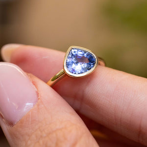 Featuring a pear-cut blue sapphire, this antique-inspired yellow gold solitaire ring offers a timeless engagement ring design.