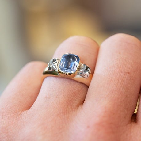 Sapphire and diamond ring highlighting central stone with subtle sparkle.
