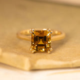 Golden-ochre chrysoberyl step-cut solitaire ring featuring a richly coloured chrysoberyl in a classic yellow gold mount.