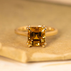 Golden-ochre chrysoberyl step-cut solitaire ring featuring a richly coloured chrysoberyl in a classic yellow gold mount.