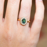 Sapphire and diamond cluster ring highlighting central stone and surrounding diamonds.