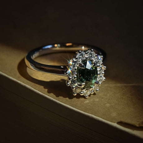 Green sapphire engagement ring with oval gemstone and diamond cluster halo