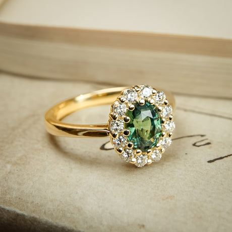 Green sapphire and diamond cluster engagement ring in yellow gold