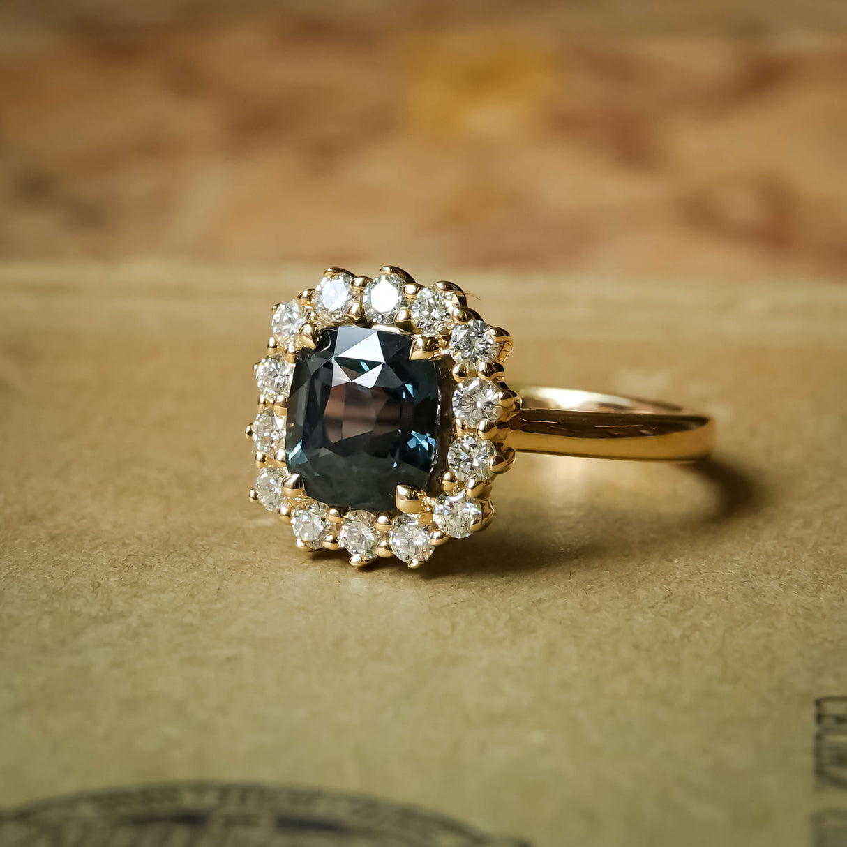 Green sapphire and diamond cluster halo engagement ring in yellow gold setting