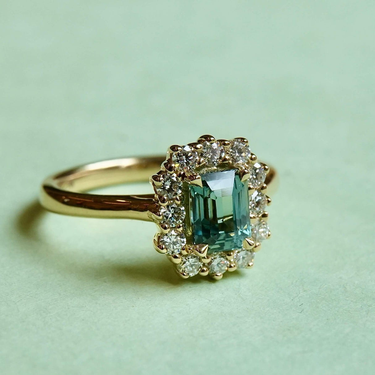 reen sapphire engagement ring surrounded by round diamond cluster halo